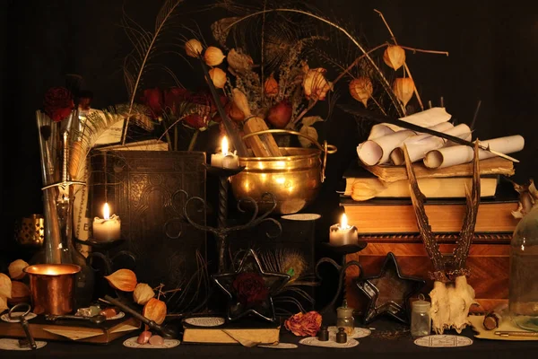 Kara büyü büyü. Wiccan büyüler ve otlar. Hala canlı: Eski yağ lambaları, antika kitap, bakır kase, ilaç şişeleri, lavanta, Pulsatilla pratensis bir antika arka plan üzerinde yanan bir muma gül tomurcukları kurutulmuş. Wicca arka plan.