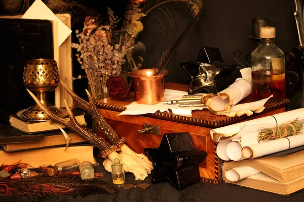 Kara büyü büyü. Wiccan büyüler ve otlar. Hala canlı: Eski yağ lambaları, antika kitap, bakır kase, ilaç şişeleri, lavanta, Pulsatilla pratensis bir antika arka plan üzerinde yanan bir muma gül tomurcukları kurutulmuş. Wicca arka plan.