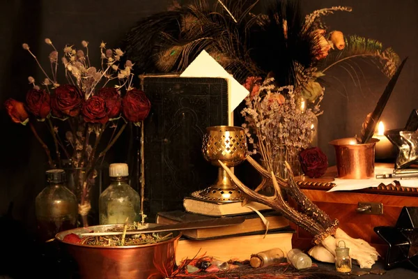 Kara büyü büyü. Wiccan büyüler ve otlar. Hala canlı: Eski yağ lambaları, antika kitap, bakır kase, ilaç şişeleri, lavanta, Pulsatilla pratensis bir antika arka plan üzerinde yanan bir muma gül tomurcukları kurutulmuş. Wicca arka plan.