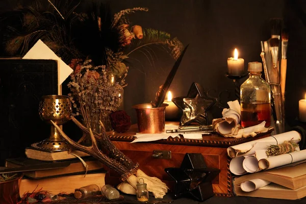 Kara büyü büyü. Wiccan büyüler ve otlar. Hala canlı: Eski yağ lambaları, antika kitap, bakır kase, ilaç şişeleri, lavanta, Pulsatilla pratensis bir antika arka plan üzerinde yanan bir muma gül tomurcukları kurutulmuş. Wicca arka plan.