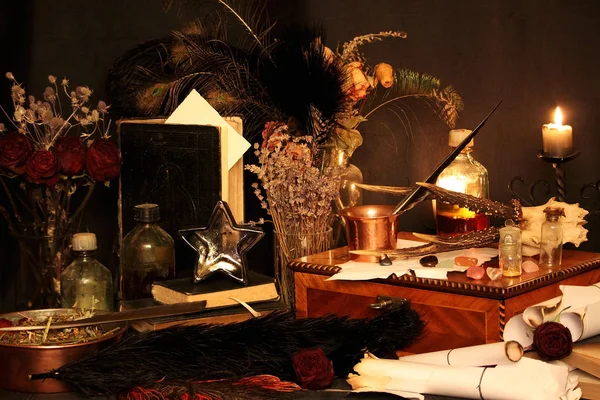 Kara büyü büyü. Wiccan büyüler ve otlar. Hala canlı: Eski yağ lambaları, antika kitap, bakır kase, ilaç şişeleri, lavanta, Pulsatilla pratensis bir antika arka plan üzerinde yanan bir muma gül tomurcukları kurutulmuş. Wicca arka plan.