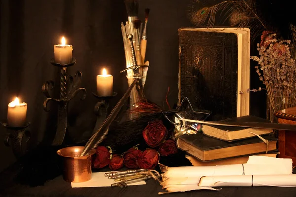 Kara büyü büyü. Wiccan büyüler ve otlar. Hala canlı: Eski yağ lambaları, antika kitap, bakır kase, ilaç şişeleri, lavanta, Pulsatilla pratensis bir antika arka plan üzerinde yanan bir muma gül tomurcukları kurutulmuş. Wicca arka plan.