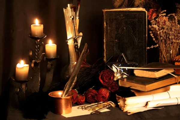 Kara büyü büyü. Wiccan büyüler ve otlar. Hala canlı: Eski yağ lambaları, antika kitap, bakır kase, ilaç şişeleri, lavanta, Pulsatilla pratensis bir antika arka plan üzerinde yanan bir muma gül tomurcukları kurutulmuş. Wicca arka plan.