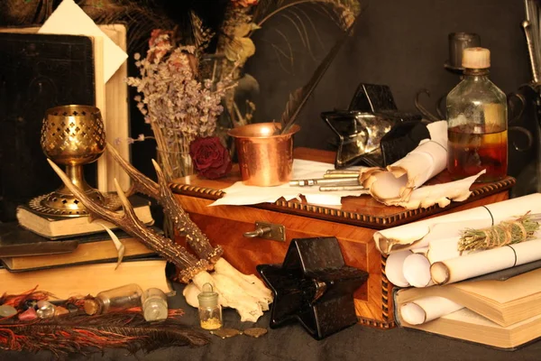 Kara büyü büyü. Wiccan büyüler ve otlar. Hala canlı: Eski yağ lambaları, antika kitap, bakır kase, ilaç şişeleri, lavanta, Pulsatilla pratensis bir antika arka plan üzerinde yanan bir muma gül tomurcukları kurutulmuş. Wicca arka plan.