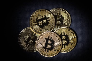 Altın bitcoin siyah arka plan üzerine yalan yığını