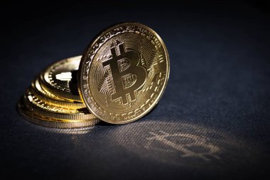 Siyah zemin üzerine altın bitcoin yığını