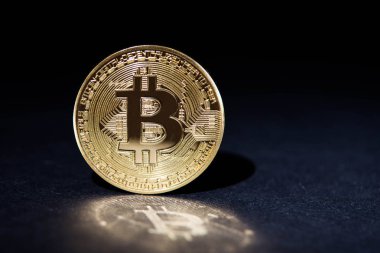 Siyah arka plan üzerine yansıması ile altın bitcoin
