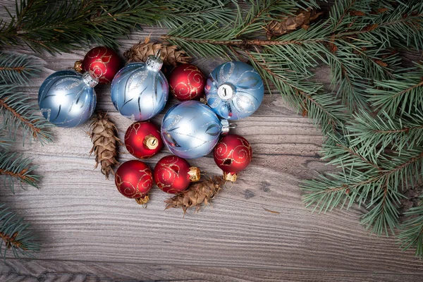 Dekorative Christbaumkugeln Und Tannenzweige Mit Tannenzapfen Auf Holzgrund — Stockfoto