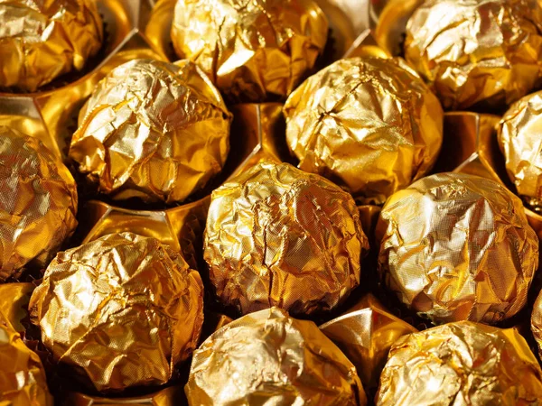 Chocolate candies in a gold wrapper, sweet chocolate candies. The view from the top