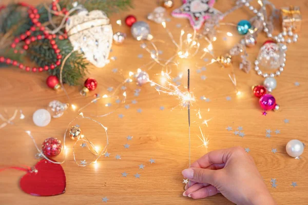 Conceito Natal Mão Humana Segurar Sparkler Com Luzes Festivas Enfeites — Fotografia de Stock