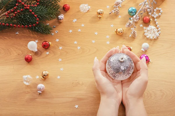 Koncepcja Świąt Ludzka Ręka Trzyma Szklaną Bombkę Świąteczną Świątecznymi Światłami — Zdjęcie stockowe