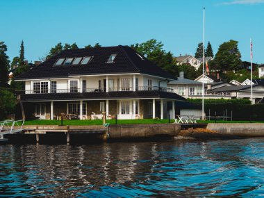 Oslo fiyordunda beyaz bir evin rıhtım manzarası. Norveç 'ten ayrılmış evler