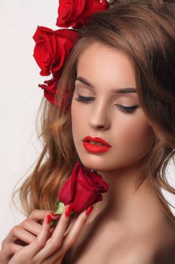 Kırmızı dudaklar ve çivi ile güzel moda kadın. Gül saç üzerinde.