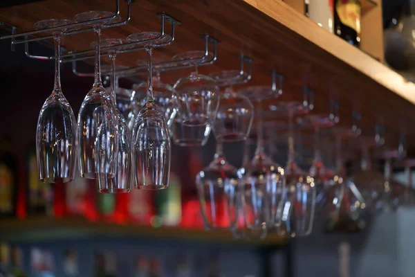 Lege glazen voor wijn boven de bar van een rek. Wijnglazen — Stockfoto