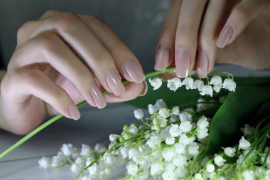 woman nails, manicure with flowers. Nails covered with nude nail polish. clipart