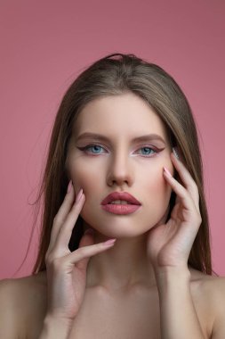 Çiçek olan kadın güzellik portresi. Profesyonel makyaj ve tırnak sanat manikür üzerinde pembe bir arka plan ile model kız.