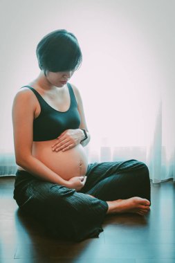 Elleri karnında hamile bir kadına yakın dur..