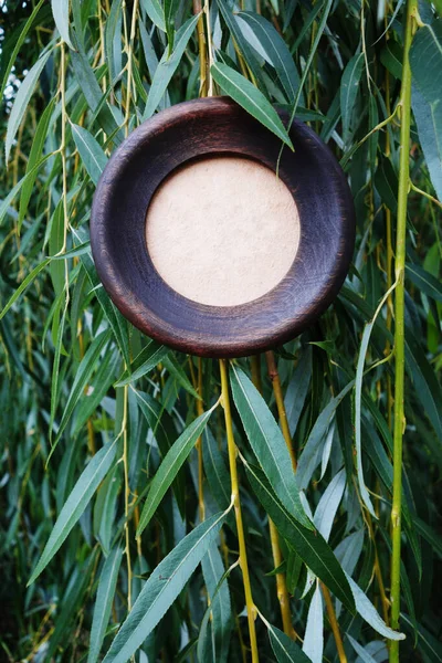 Struttura rotonda di legno su uno sfondo di foglie di salice . — Foto Stock