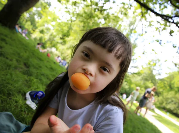 公園でアプリコットを食べる少女 — ストック写真