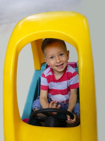 車で遊ぶかわいい笑みを浮かべて男の子 — ストック写真