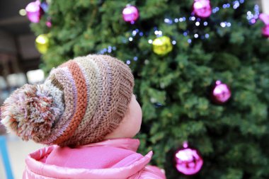 Yılbaşı ağacının arka planında genç bir kızın portresi