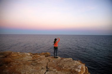 Günbatımı'nın deniz kıyısında telefonda kadınla