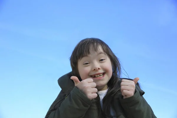 青空の背景に笑みを浮かべて少女の肖像画 — ストック写真