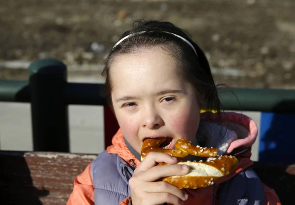 小女孩吃椒盐卷饼的画像 — 图库照片