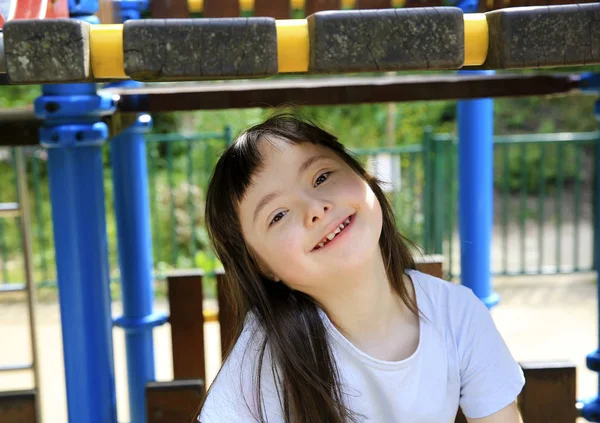 Parkta gülümseyen küçük kızın portresi.