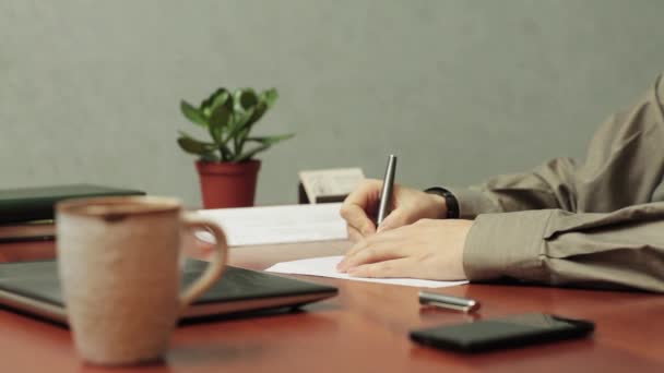 Человек подписывает конверт и кладет письмо на стол в офисе — стоковое видео