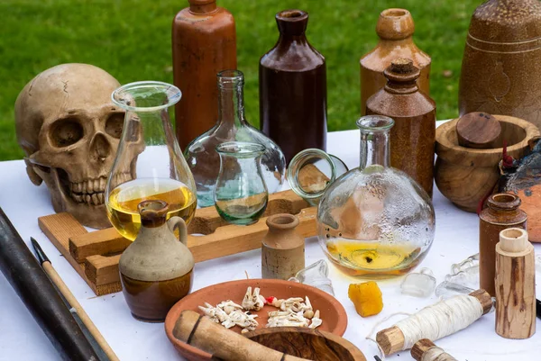中世纪药典的桌子与瓶子罐和头骨 — 图库照片