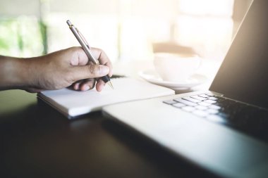 Sabah notbook üzerinde yazılı bir iş adamı.