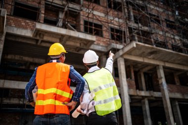 İnşaat alanında çalışan iki inşaat mühendisi ve şantiyede yönetici.