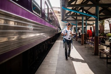Gezgin backpacking ve yalnız tren istasyonuna yürüyüş vardır