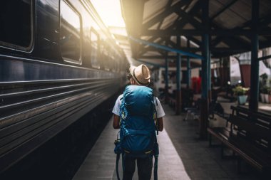 Gezgin backpacking ve yalnız tren istasyonuna yürüyüş vardır.