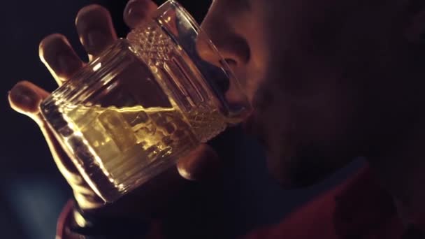 Um homem de camisa vermelha bebe uísque no bar. — Vídeo de Stock