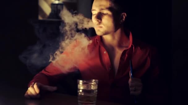 Un uomo con una camicia rossa sta bevendo whisky al bar. — Video Stock