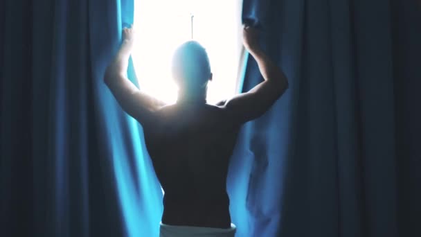 Man opens the curtains in the morning — Stock Video