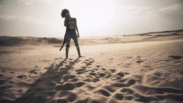 Женщина в ветреной пустыне — стоковое видео