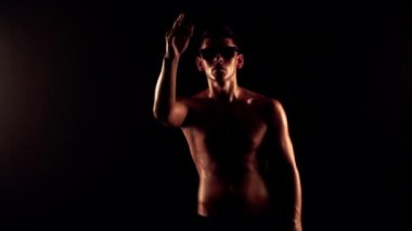 Seksi erkek siyah arka plan üzerinde dans ediyor