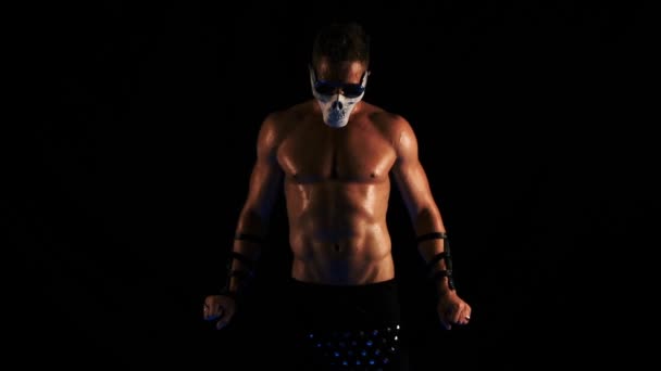 Mann mit Totenkopf-Maske und Brille tanzt auf schwarzem Hintergrund — Stockvideo