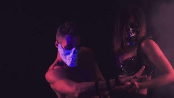 Muž a žena tanec v maskách lebka