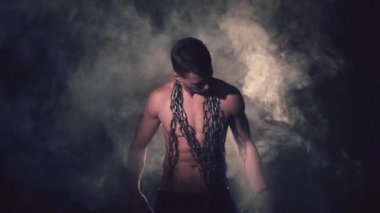 Metal zincirler duman içinde adam