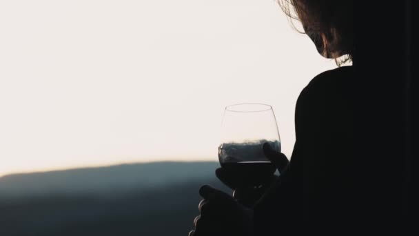 Mulher com um copo de vinho tinto no terraço — Vídeo de Stock