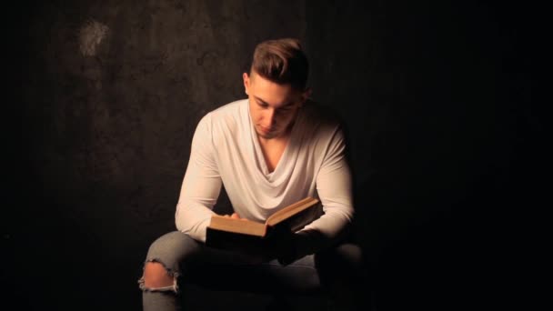 Junger Mann liest ein altes Buch — Stockvideo