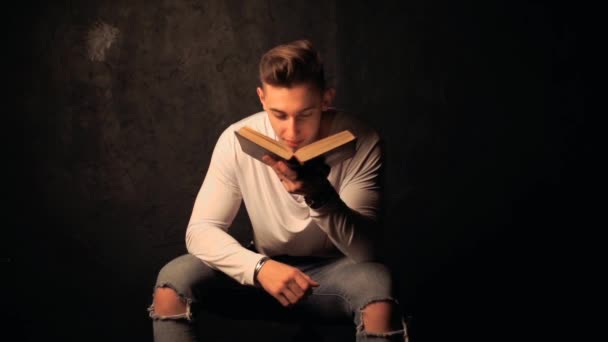 Молодой человек, читающий старую книгу — стоковое видео