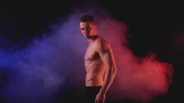 Sexy muž v barevné kouřové pozadí — Stock video