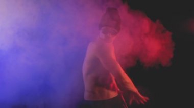 Renkli bir dumanlı arka plan üzerinde güneş gözlüklü genç adam