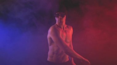 Dumanlı bir arka plan üzerinde güneş gözlüklü genç adam