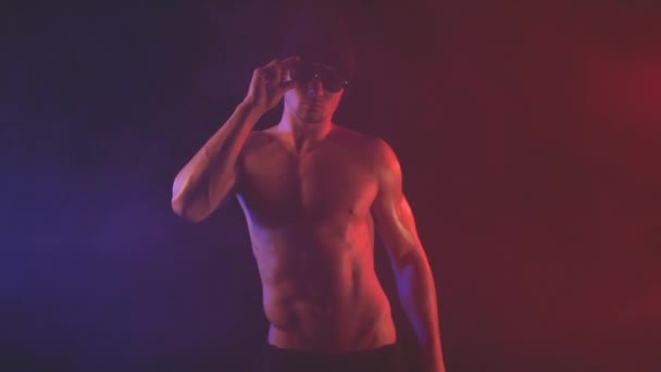 Junger Mann mit Sonnenbrille vor verrauchtem Hintergrund — Stockvideo
